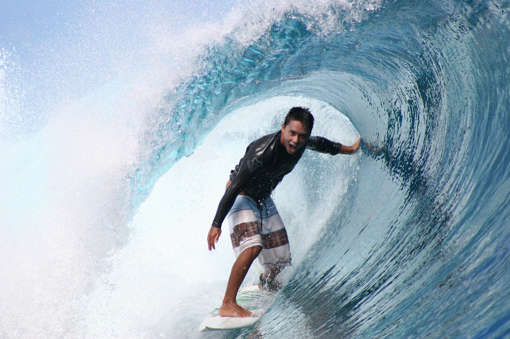 Dennis Tihara riding a wave at Teahupoo, Tahiti.