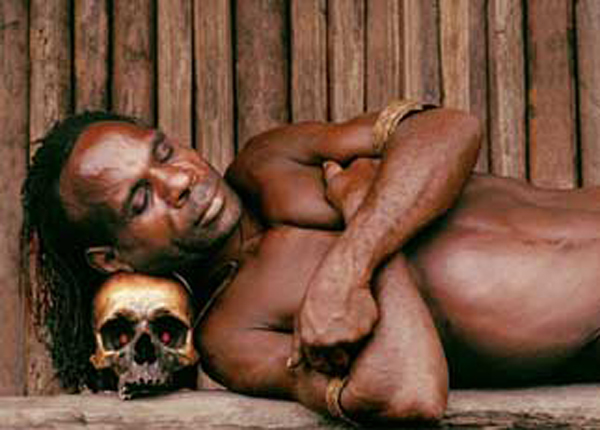 An Asmat tribal man sleeping on a human skull. Photo credit unknown.