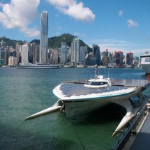 hong-kong-skyline-panet-solar Hong Kong skyline with the ship "PlanetSolar" in Victoria Harbour.