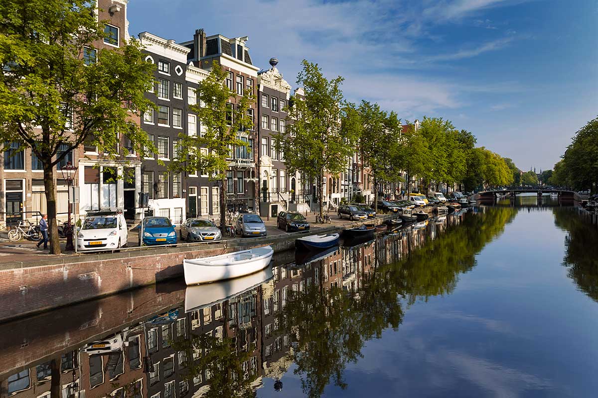 Walking along the canals in Amsterdam is especially cool in the morning. Then you'll get the chance to see the beautiful reflections.