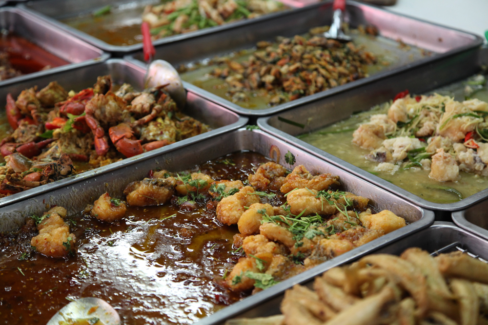 Different varieties of food/curry at a food vendor in Bangkok.