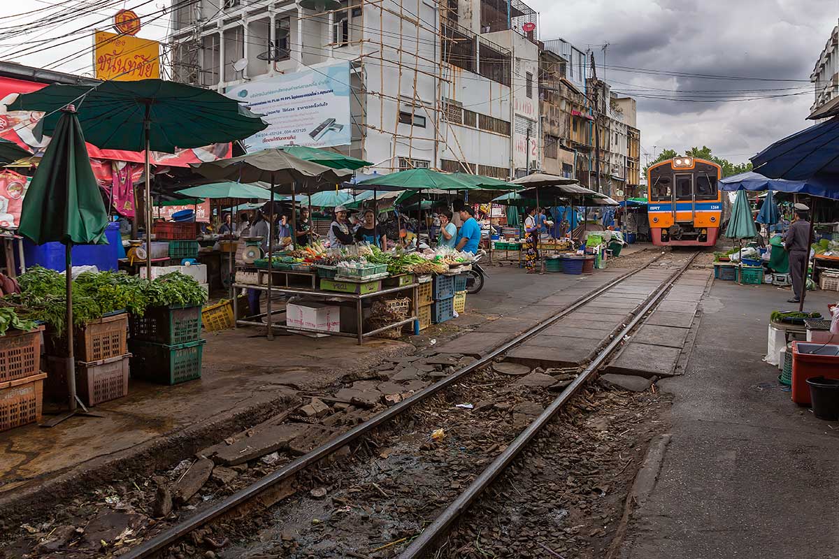 Mahachai market and the railway live next to each other, so when the first train arrives from Bangkok, vendors have to move their wares off the tracks for the train to pull into the station. Mahachai market and the railway live next to each other, so when the first train arrives from Bangkok, vendors have to move their wares off the tracks for the train to pull into the station.