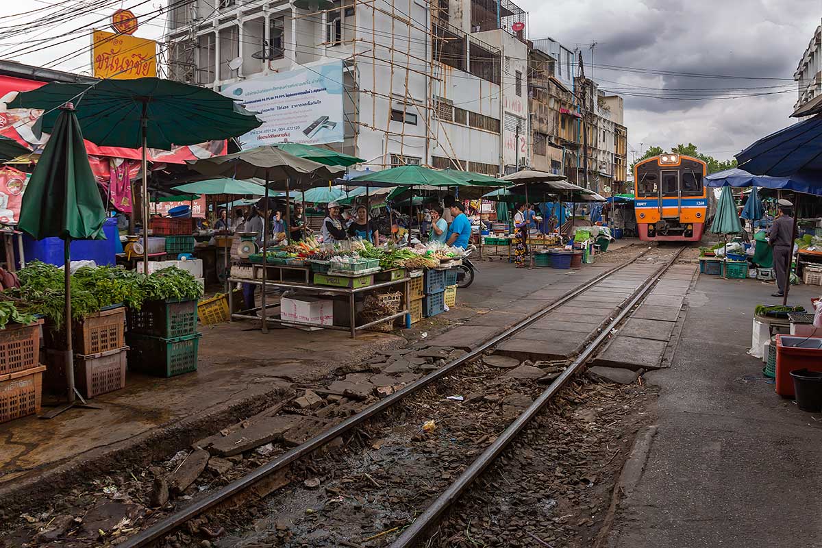 Mahachai market and the railway live next to each other, so when the first train arrives from Bangkok, vendors have to move their wares off the tracks for the train to pull into the station.