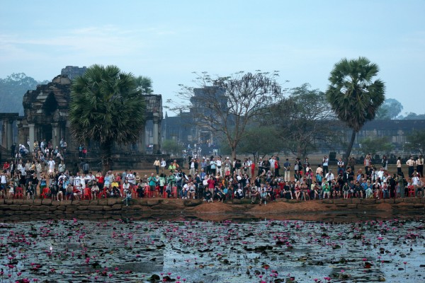 tourists-waiting-angkor-wat-cambodia Tourist in front of the main temple at sunrise.