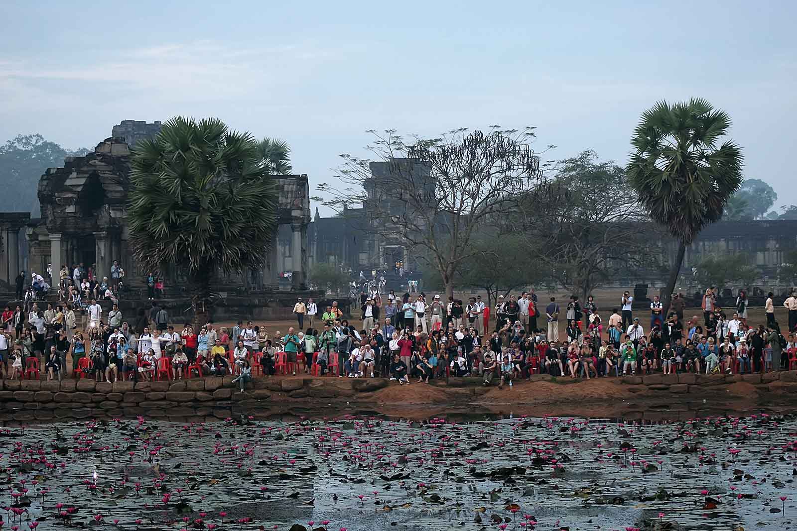 tourists-waiting-angkor-wat-cambodia Tourist in front of the main temple at sunrise.