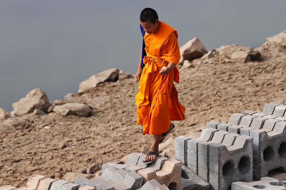monk-walking-along-mekong-river-laos Communist Laos has around 5 million Buddhists, who form roughly 70% of its population.