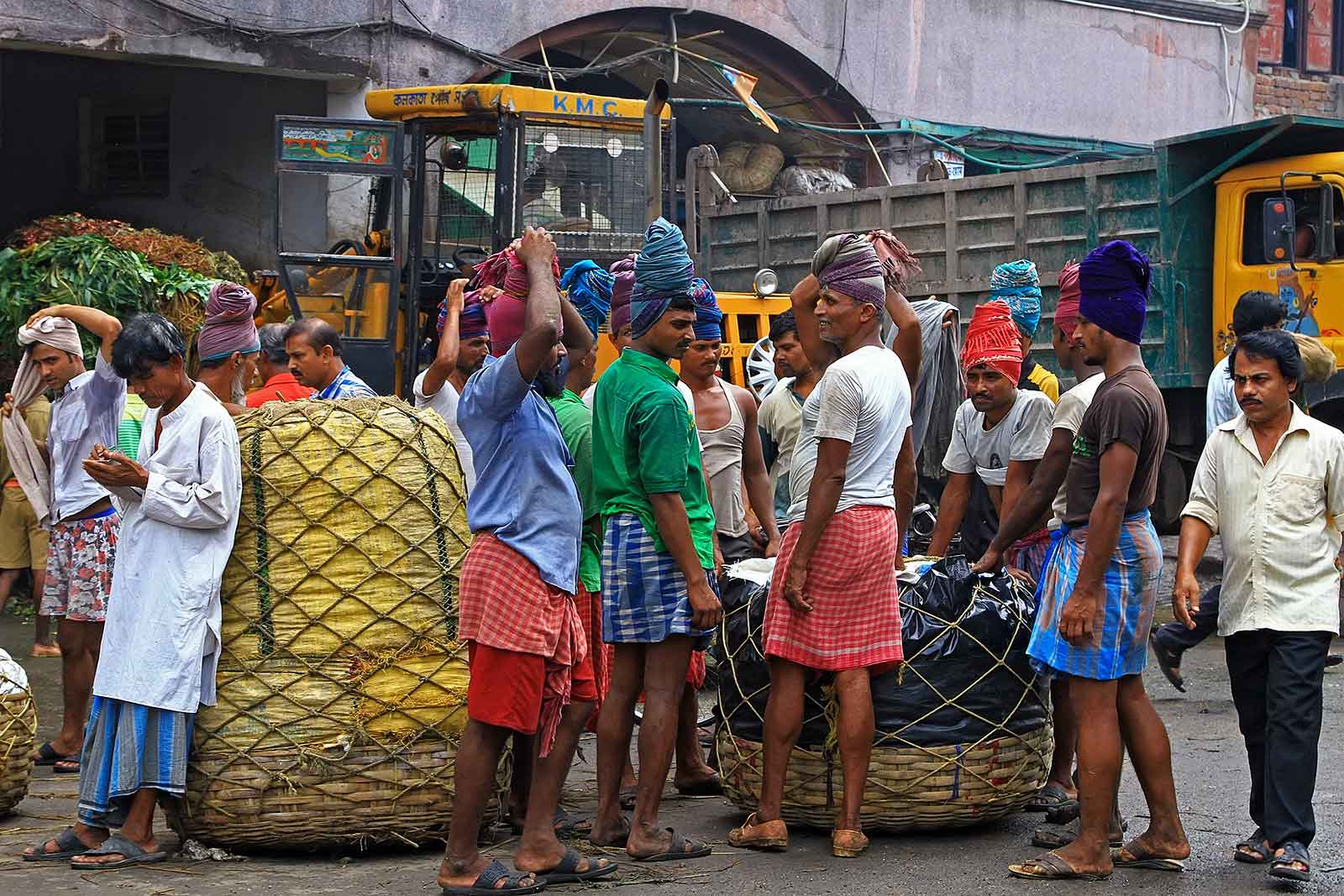 Getting ready to lift up a heavy pile of vegetables in Kolkata, India.