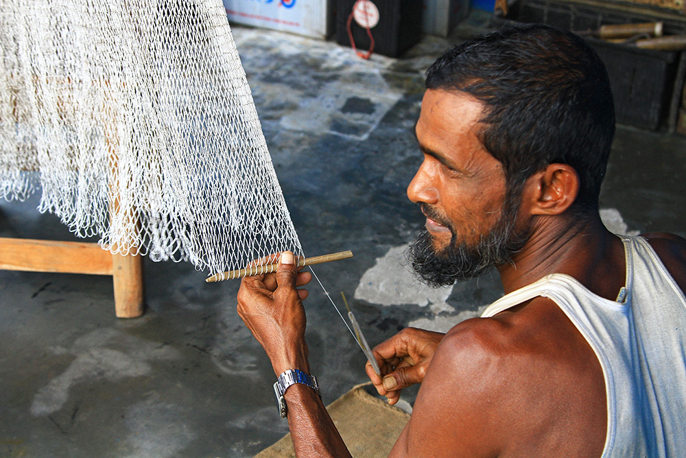 Producing fishing nets by hand in Kuakata, Bangladesh.