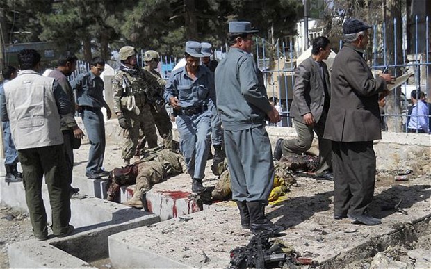  Afghan policemen and NATO troops inspect the site of a suicide attack in Faryab province, Afghanistan. Photo: REUTERS