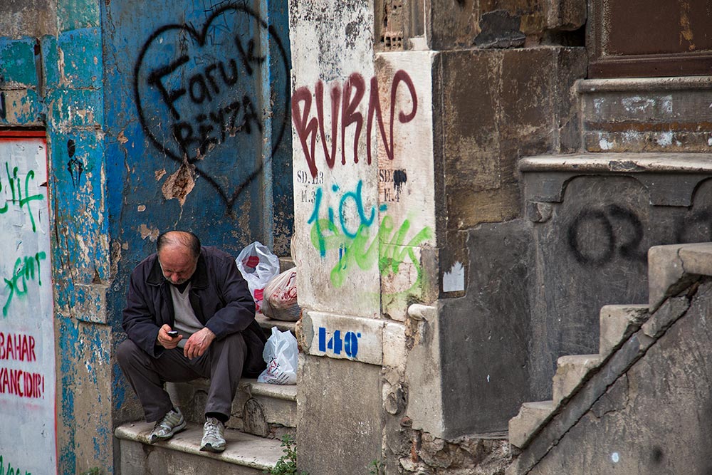 A man sitting in the doorway of a house in Galata, Istanbul.