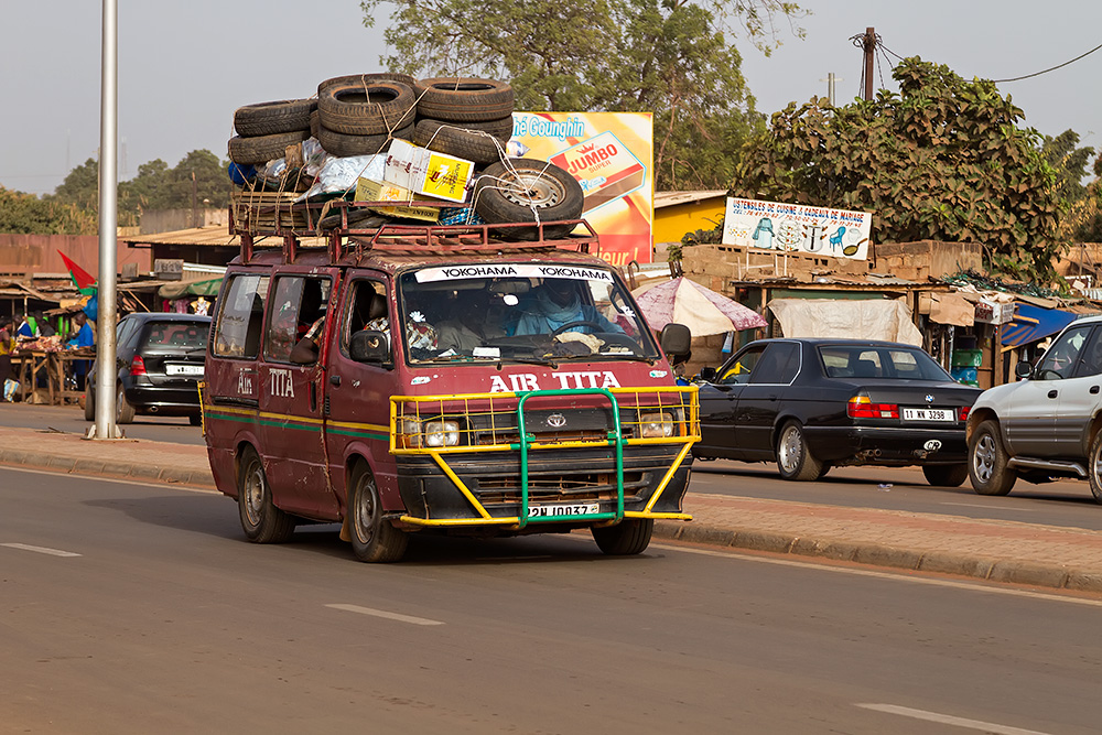 Fully loaded bush taxi in Ouagadougou, Burkina Faso - A couple of tyres in tow to be on the safe side...