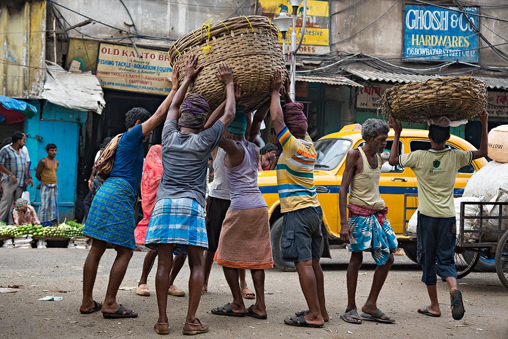 Hard working men at Kolay Market in Kolkata, India.