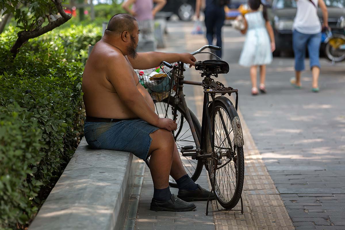 chinese-man-topless-streets-guangzhou-china Shirtless Chinese sitting in the streets of Guangzhou.