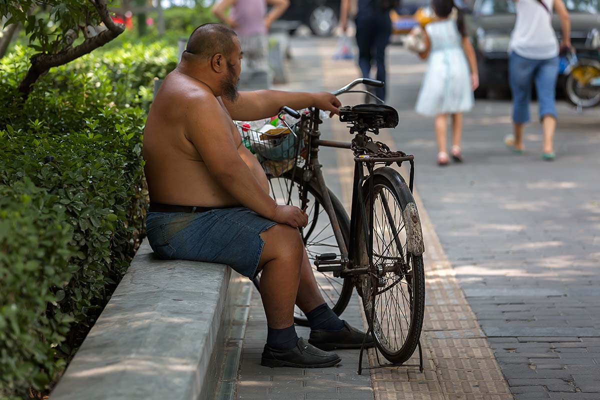 Shirtless Chinese sitting in the streets of Guangzhou.