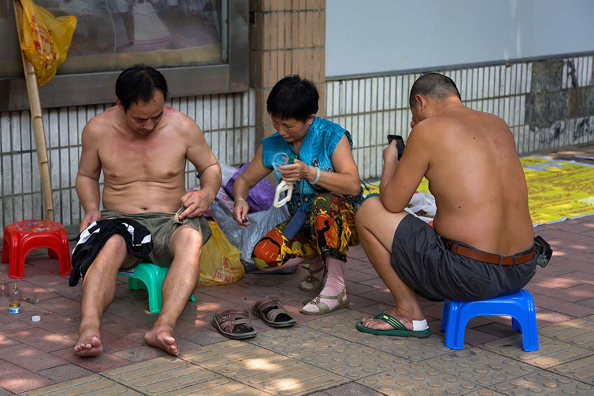 Shirtless Chinese men in the streets of Beijing.