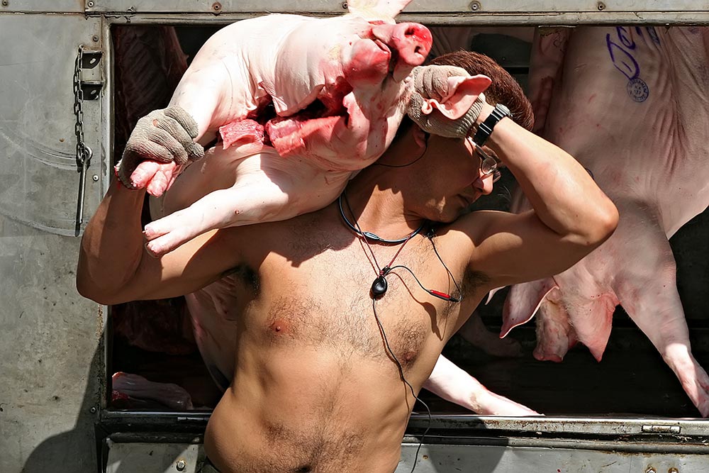 A shirtless butcher in Hong Kong.