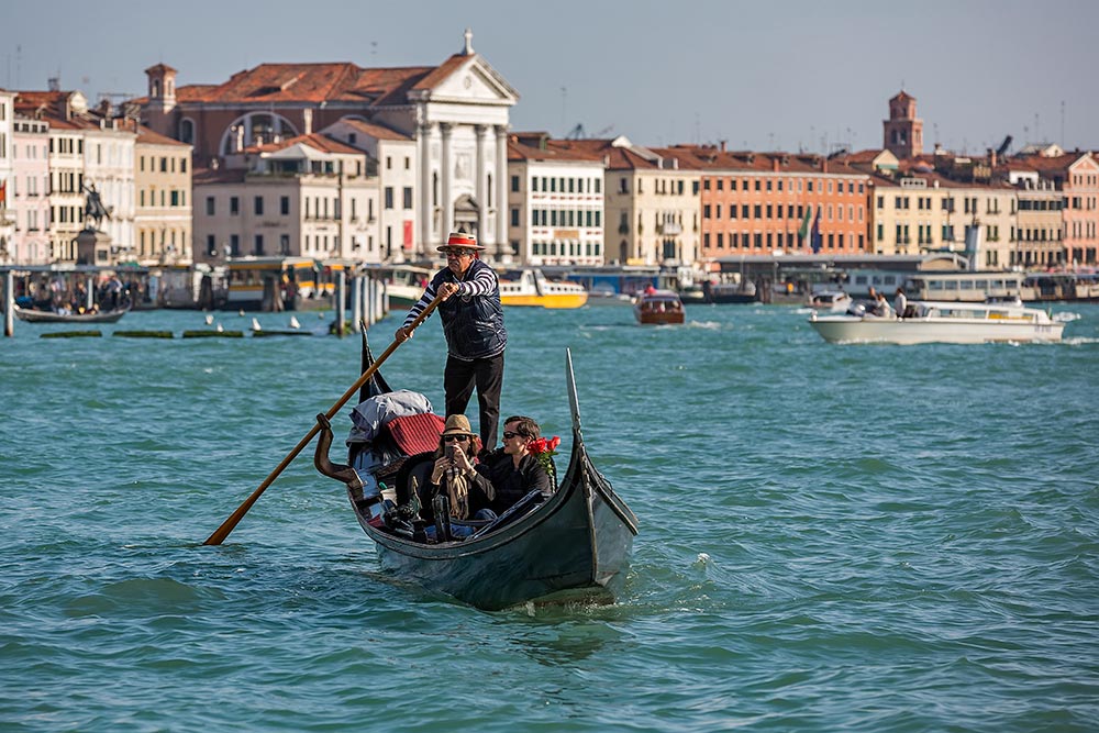 For centuries gondolas were the chief means of transportation and most common watercraft within Venice. It's driven by a gondolier. In modern times the iconic boats still have a role in public transport in the city, serving as ferries over the Grand Canal.