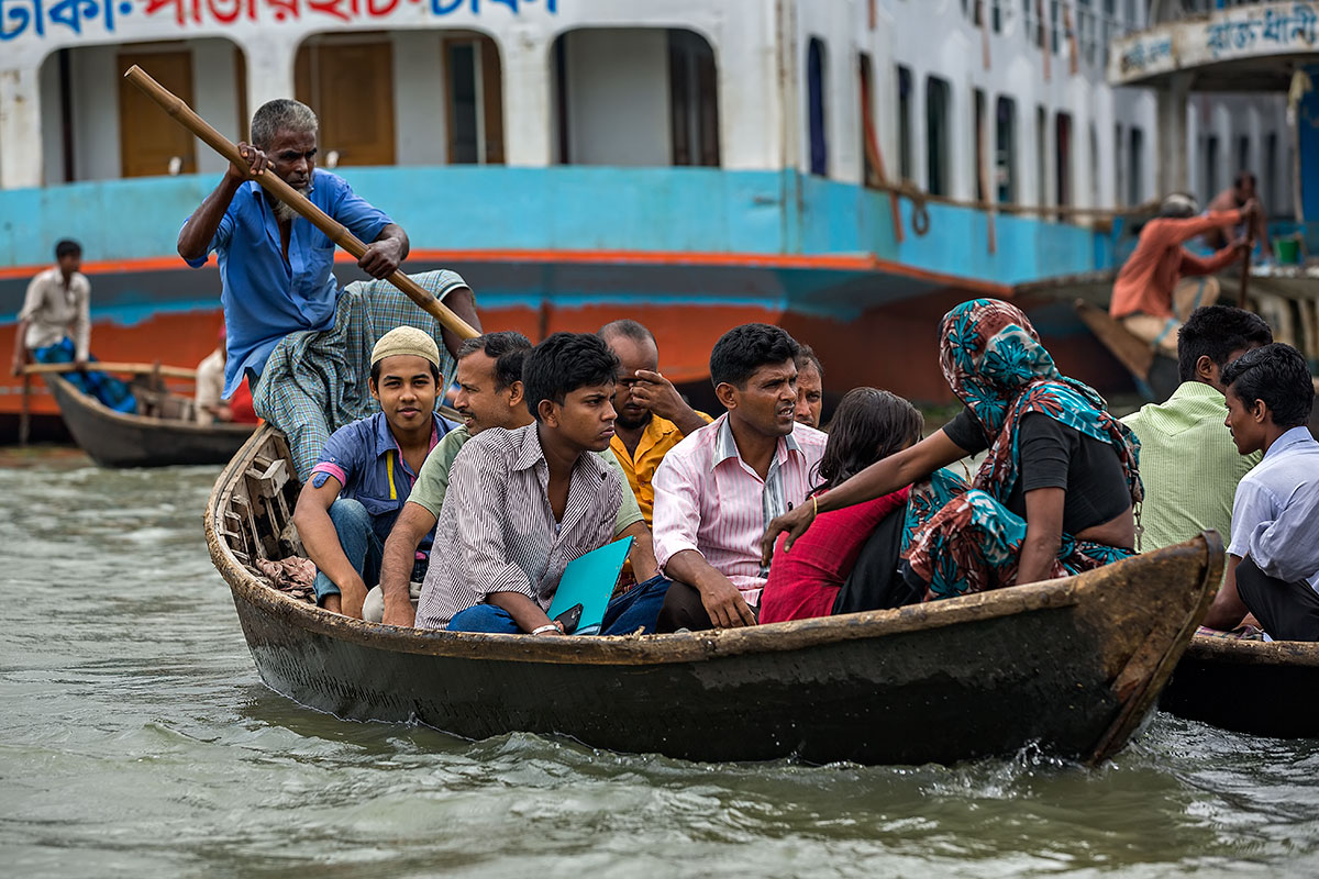 A ferryman taking people across the Buriganga River in his wooden boat. The Buriganga river is one of the most dangerous waterways on Earth, especially for the ferrymen.