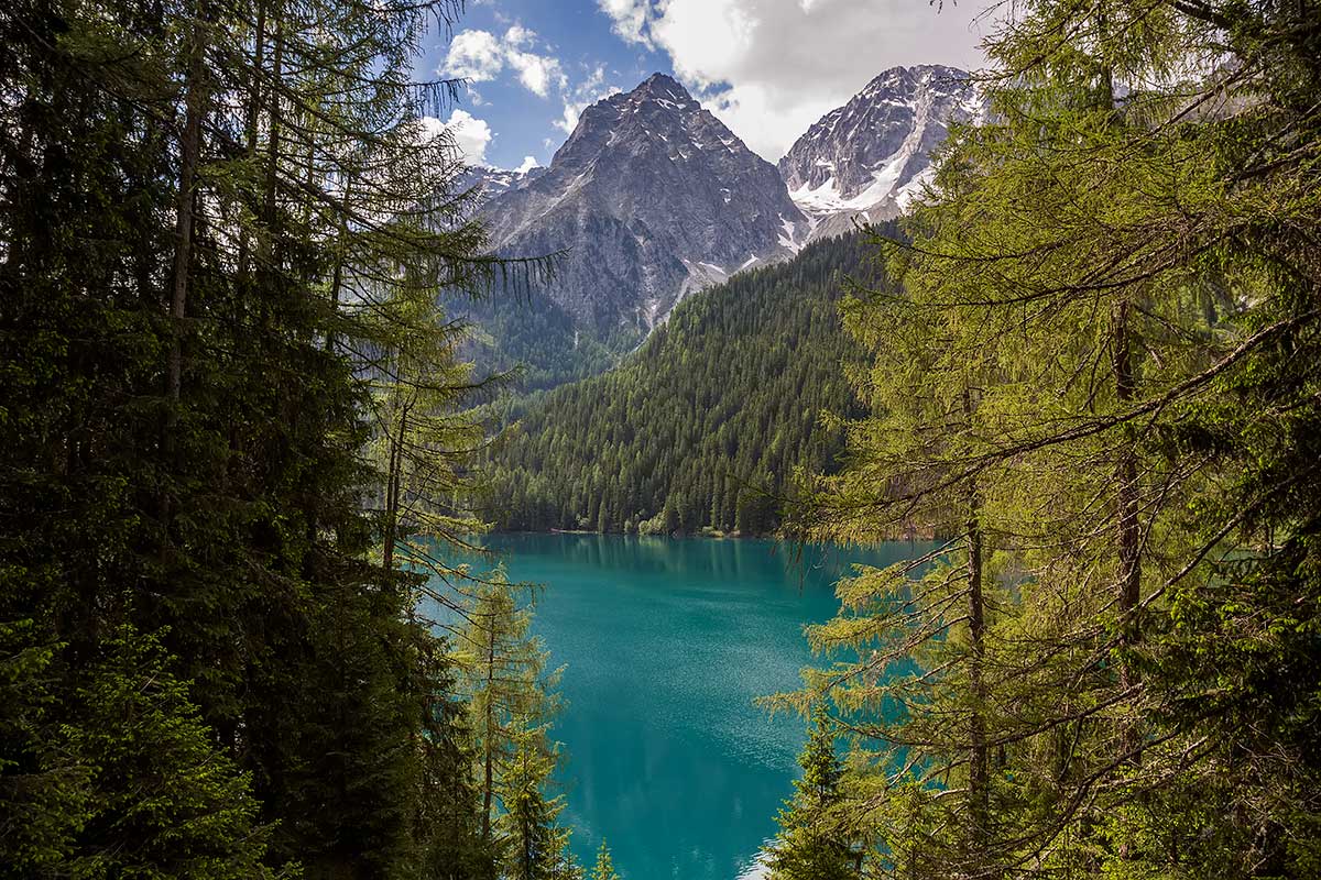 Walking around the Antholzer See, South Tyrol, will give you some of the most stunning impressions in the area... Mountains and blue water at the Antholzer See in South Tyrol, Italy.
