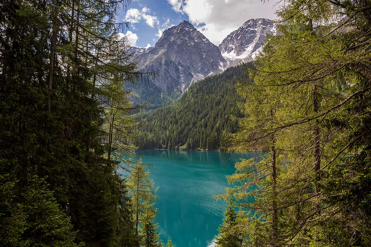 Mountains and blue water at the Antholzer See in South Tyrol, Italy.