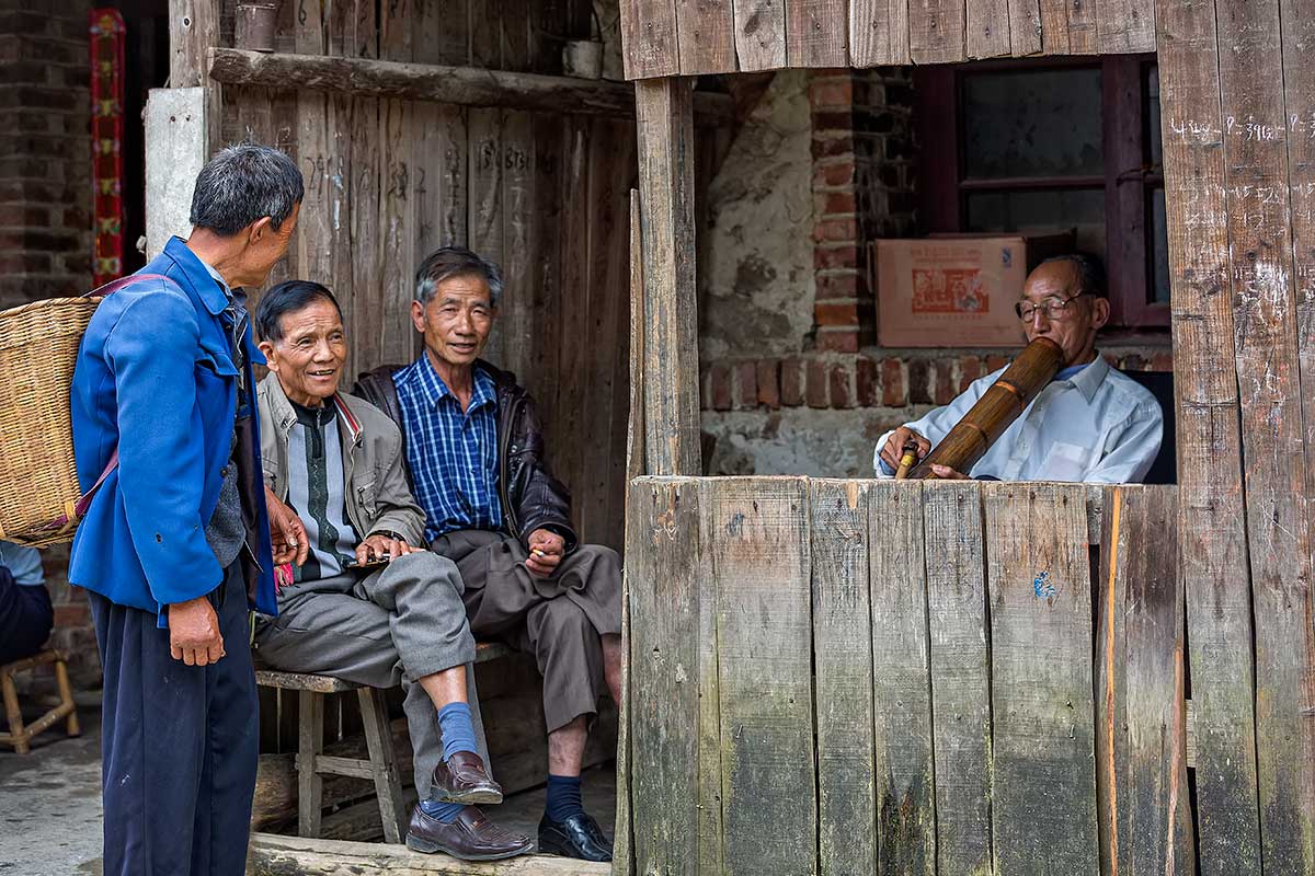 Men smoking a pipe in Xinjie, Yunnan Province, China.