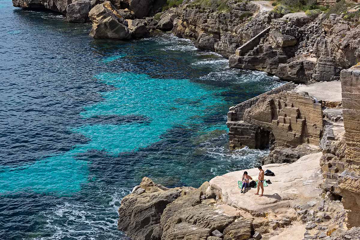 It's quite a scramble to get down the rocks of Cala Rossa beach, but determined holiday-makers don't this obstacle keep them from it.