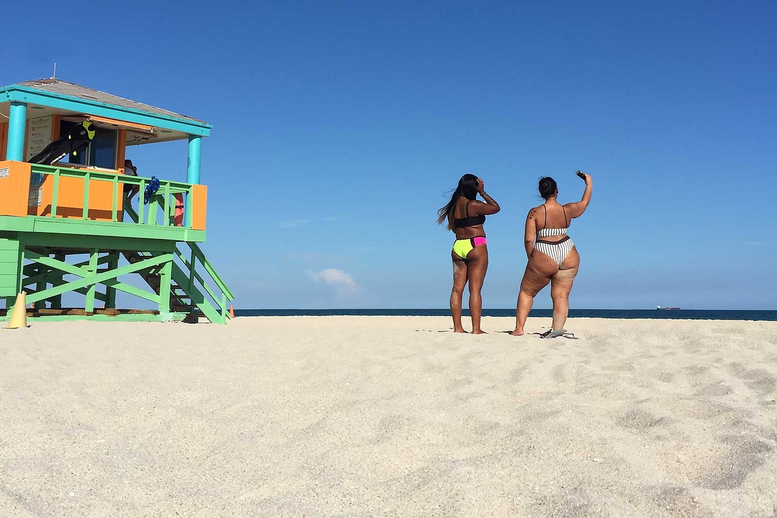 Beautiful people wander along the beaches of Miami, posing and taking selfies...