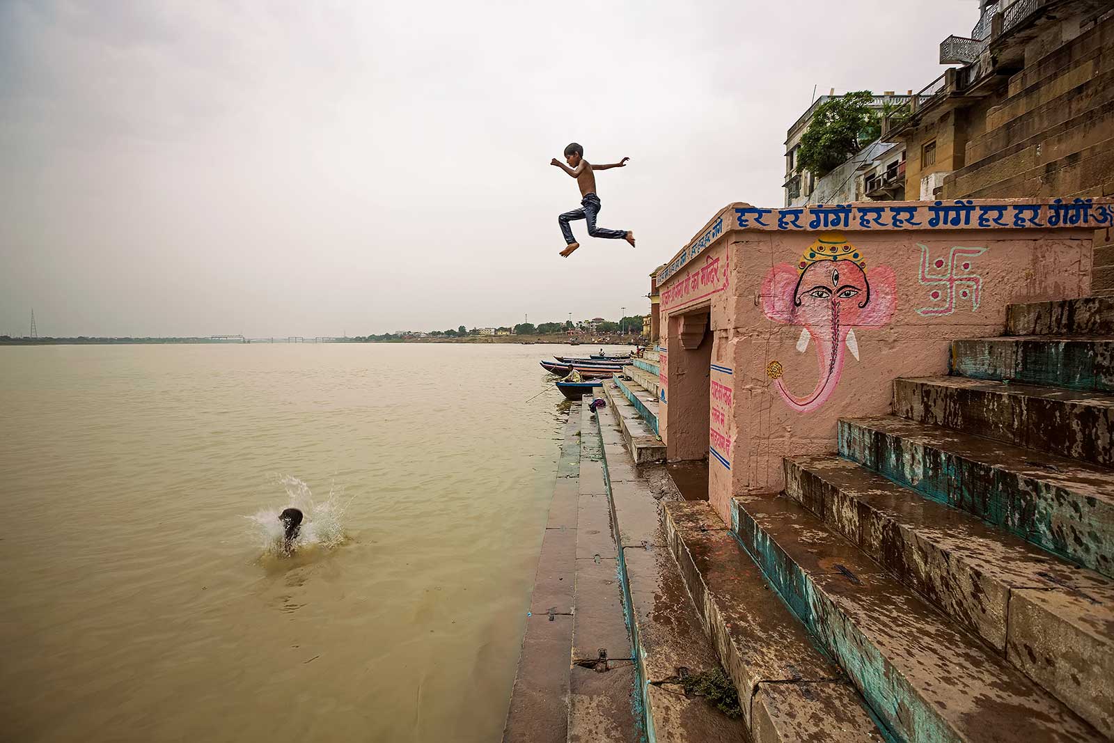 Kids jumping into the Ganges river while walking along the Ghats in Varanasi.