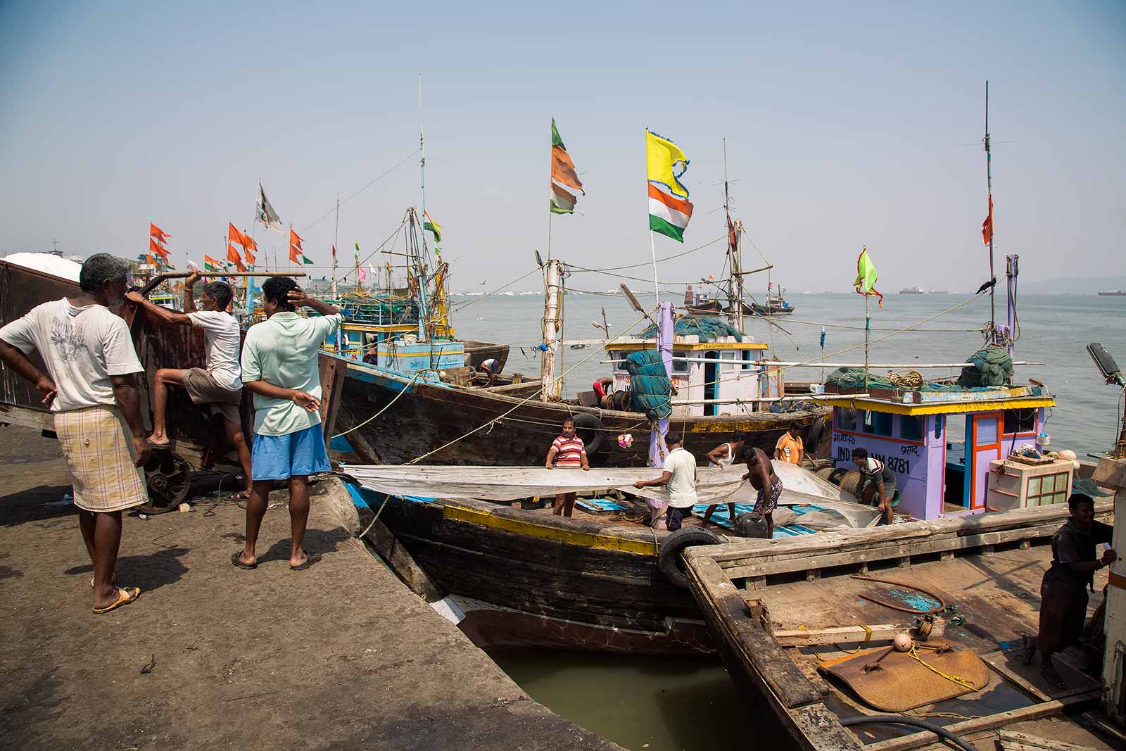 These men at Sassoon Docks are refilling the boats with crushed ice for their next trip out to sea.